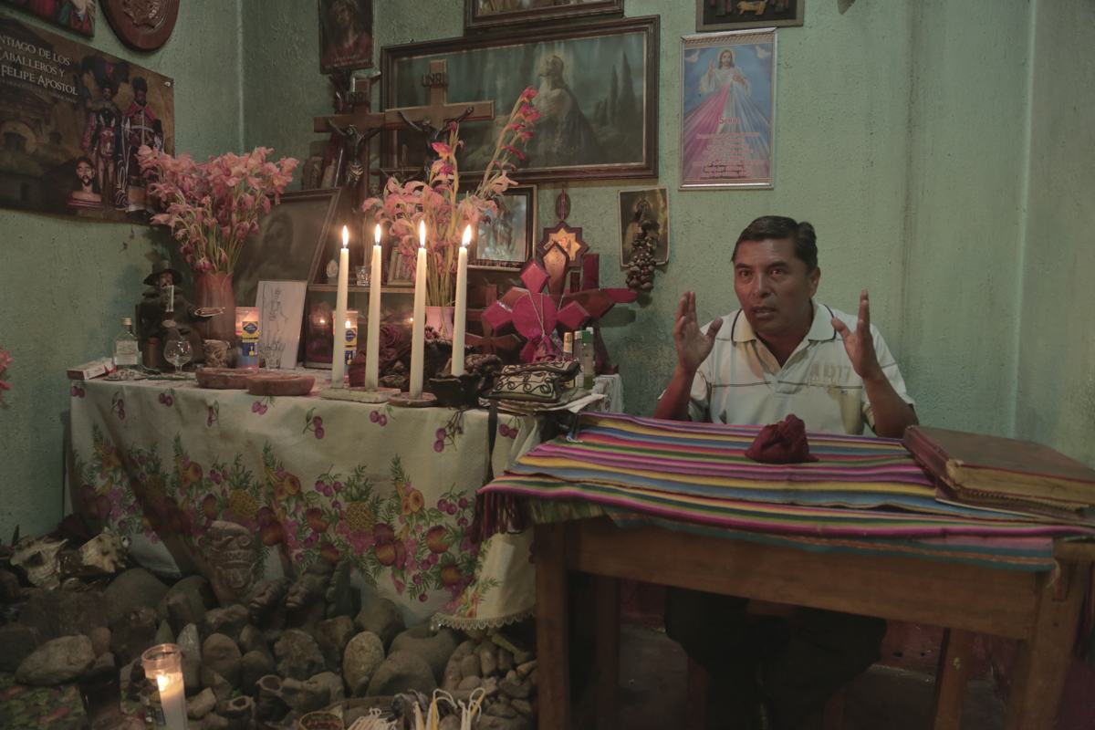 A spiritual guide speaks beside a candlelit home altar