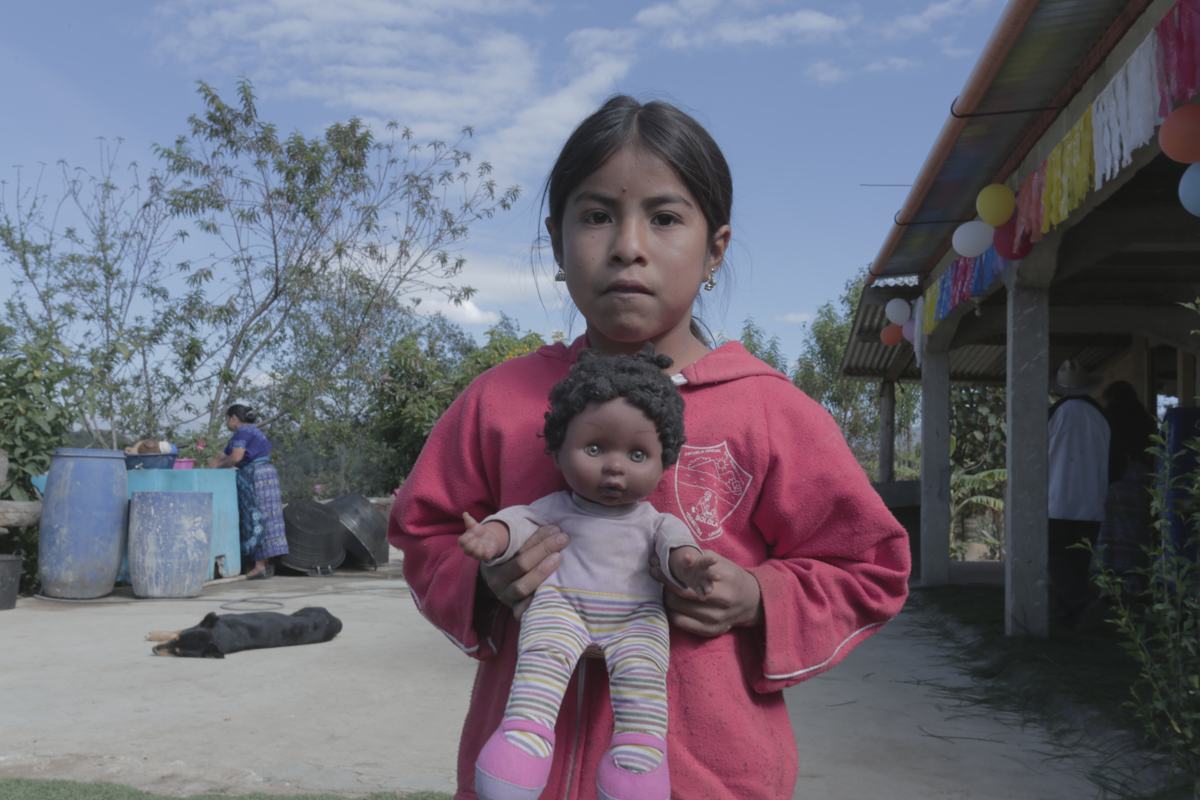 A girl holds her doll