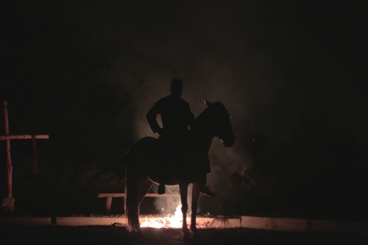 A rider silhouetted against fire