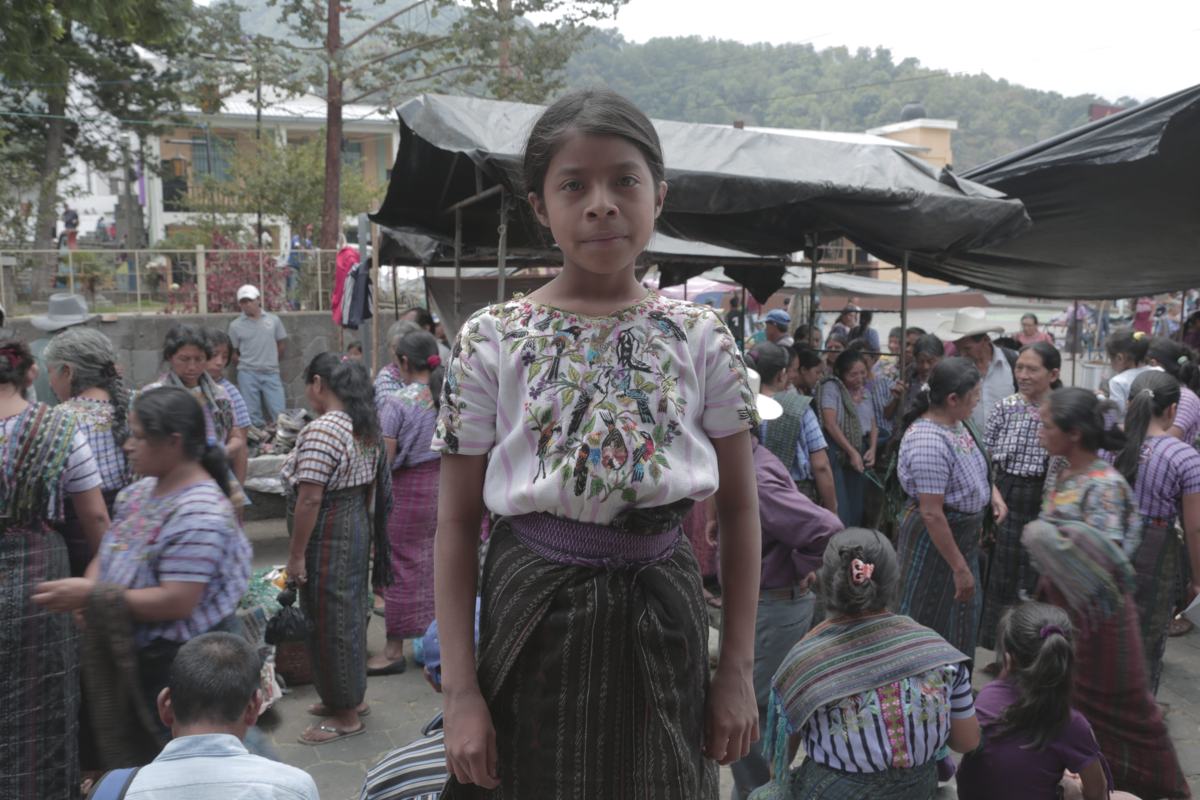 A girl stands in a busy market